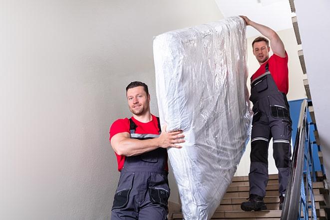 heavy lifting as a box spring is carried out of a house in Auburn, WA